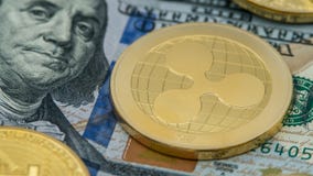 Guld- Ripplecoin för fysisk metall valuta över diferentsdollarräkningar arkivfoto Guld- Ripplecoin för fysisk metall valuta över diferentsdollarräkningar arkivfoto