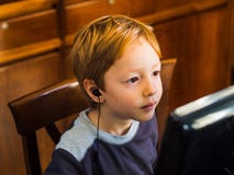 Gullig pys som spelar på den koncentrerade PC:n royaltyfria bilder Gullig pys som spelar på den koncentrerade PC:n royaltyfria bilder