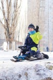 Gullig sledding för barn Litet barnpojke som rider en pulka i snön arkivfoto Gullig sledding för barn Litet barnpojke som rider en pulka i snön arkivfoto