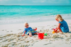 Gulliga små flickor spelar med sand på stranden arkivfoto Gulliga små flickor spelar med sand på stranden arkivfoto