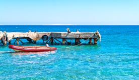 Gummiboot nahe dem Pier im Meer lizenzfreie stockbilder Gummiboot nahe dem Pier im Meer lizenzfreie stockbilder