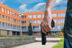 Gun control concept. Young armed man holds pistol in hand in public near school. Royalty Free Stock Photo Gun control concept. Young armed man holds pistol in hand in public near school. Royalty Free Stock Photo
