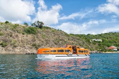Gustavia, stbarts - 25 de novembro de 2015: curso do navio no mar azul ao longo do litoral Transporte e embarcação da água Viajan Fotografia de Stock Royalty Free Gustavia, stbarts - 25 de novembro de 2015: curso do navio no mar azul ao longo do litoral Transporte e embarcação da água Viajan Fotografia de Stock Royalty Free