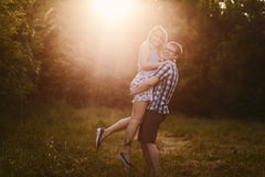 Guy holds a girl on hands in sunset light stock photography Guy holds a girl on hands in sunset light stock photography