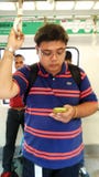 Guy Riding der Nahverkehrszug in Singapur lizenzfreie stockfotografie Guy Riding der Nahverkehrszug in Singapur lizenzfreie stockfotografie