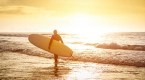 Guy surfer walking with surfboard at sunset in Tenerife - Surf concept Royalty Free Stock Photo Guy surfer walking with surfboard at sunset in Tenerife - Surf concept Royalty Free Stock Photo