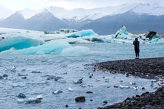 Guy takes pictures of the iceberg and the whole glacier in Iceland royalty free stock photography Guy takes pictures of the iceberg and the whole glacier in Iceland royalty free stock photography