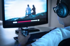 Guy watching movie or series online from streaming service and drinking can of soda. Internet on demand video player in computer. stock photo Guy watching movie or series online from streaming service and drinking can of soda. Internet on demand video player in computer. stock photo