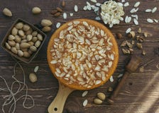 Gâteau d'amande dans le plat en bois et servi avec les amandes écossées délicieuses A décoré des amandes crues fraîches images libres de droits Gâteau d'amande dans le plat en bois et servi avec les amandes écossées délicieuses A décoré des amandes crues fraîches images libres de droits