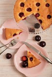 Gâteau fait maison de prune sur un support en verre et des plats roses Image libre de droits Gâteau fait maison de prune sur un support en verre et des plats roses Image libre de droits