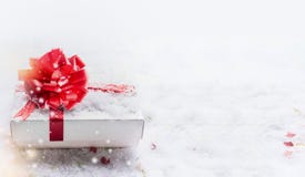 Gåvaask för vit jul med den röda pilbågen på snö med bokeh och snöfall, baner royaltyfri bild Gåvaask för vit jul med den röda pilbågen på snö med bokeh och snöfall, baner royaltyfri bild