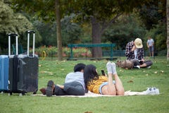 Gör förälskade lögner för asiatiska par på gräset och selfies på Champ de Mars i Paris royaltyfria bilder Gör förälskade lögner för asiatiska par på gräset och selfies på Champ de Mars i Paris royaltyfria bilder