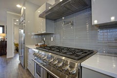 Göra slät den moderna kökdesignen med en glansig grå backsplash arkivfoton Göra slät den moderna kökdesignen med en glansig grå backsplash arkivfoton
