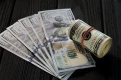 Gęsta rolka starzy sto dolarowych banknotów wiązał gumowego zespołu czerwonych kłamstwa na bokobrody nowi sto dolarowych rachunkó fotografia stock Gęsta rolka starzy sto dolarowych banknotów wiązał gumowego zespołu czerwonych kłamstwa na bokobrody nowi sto dolarowych rachunkó fotografia stock