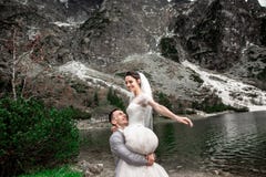 H?rlig gifta sig photosession Brudgummen cirklar hans unga brud, p? kusten av sj?n Morskie Oko poland arkivfoto H?rlig gifta sig photosession Brudgummen cirklar hans unga brud, p? kusten av sj?n Morskie Oko poland arkivfoto