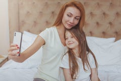 H?rlig kvinna och hennes lilla dotter som anv?nder den smarta telefonen royaltyfria bilder H?rlig kvinna och hennes lilla dotter som anv?nder den smarta telefonen royaltyfria bilder