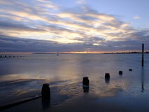 H?stsolnedg?ng ?ver Solenten fr?n den v?stra Wittering stranden, v?stra Sussex UK arkivbild H?stsolnedg?ng ?ver Solenten fr?n den v?stra Wittering stranden, v?stra Sussex UK arkivbild