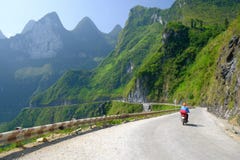 Ha Giang/Vietnam - 01/11/2017: Motorbiking fotvandrare på spolningsvägar till och med dalar och karstberglandskap i norden royaltyfri foto Ha Giang/Vietnam - 01/11/2017: Motorbiking fotvandrare på spolningsvägar till och med dalar och karstberglandskap i norden royaltyfri foto