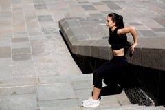 Habillement de port de sport de fille impressionnante de forme physique s'étendant à la ville L'espace pour le texte photos stock Habillement de port de sport de fille impressionnante de forme physique s'étendant à la ville L'espace pour le texte photos stock