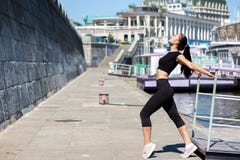 Habillement de port de sport de fille mince de brune s'étendant à la ville, près de la rivière L'espace vide photos libres de droits Habillement de port de sport de fille mince de brune s'étendant à la ville, près de la rivière L'espace vide photos libres de droits