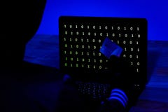 Hacker com cartão de crédito que rouba dados de um portátil na obscuridade fotografia de stock Hacker com cartão de crédito que rouba dados de um portátil na obscuridade fotografia de stock