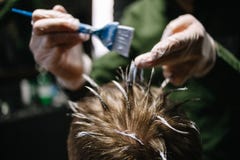 Hairdresser with a brush to apply hair dye. Coloring in the barber shop royalty free stock images Hairdresser with a brush to apply hair dye. Coloring in the barber shop royalty free stock images
