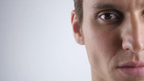 Halbes Gesichtsporträt des hübschen kaukasischen Mannes mit braunem Auge auf weißem Hintergrund stock footage Halbes Gesichtsporträt des hübschen kaukasischen Mannes mit braunem Auge auf weißem Hintergrund stock footage