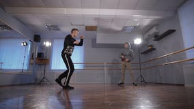 Hall для танцев репетиций 2 молодых танцора Молодой парень в черной куртке работает движения более низкого пролома акции видеоматериалы Hall для танцев репетиций 2 молодых танцора Молодой парень в черной куртке работает движения более низкого пролома акции видеоматериалы