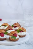 Hallon Profiteroles med vit chokladpralin arkivfoton Hallon Profiteroles med vit chokladpralin arkivfoton