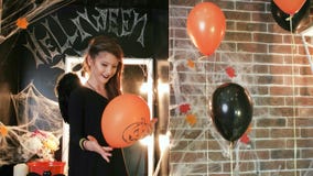 Halloween celebration, young witch playing balloon with pumpkin, teen girl wearing scary costume stock video Halloween celebration, young witch playing balloon with pumpkin, teen girl wearing scary costume stock video