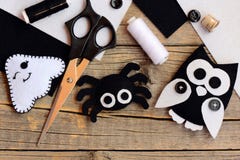 Halloween felt decorations. Felt ghost, spider, owl decorations on a vintage wooden table. Sewing tools and materials Stock Photos Halloween felt decorations. Felt ghost, spider, owl decorations on a vintage wooden table. Sewing tools and materials Stock Photos