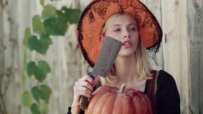 Halloween girl. Halloween woman posing with pumpkin. Glamour fashion vampire lady with witch costume. Beautiful young stock video footage Halloween girl. Halloween woman posing with pumpkin. Glamour fashion vampire lady with witch costume. Beautiful young stock video footage