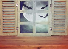 Halloween holiday concept. Empty rustic table in front of haunted night sky background and old window. Ready for product display m royalty free stock images Halloween holiday concept. Empty rustic table in front of haunted night sky background and old window. Ready for product display m royalty free stock images