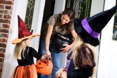 Halloween: La madre distribuye el caramelo a la bruja de la niña imágenes de archivo libres de regalías Halloween: La madre distribuye el caramelo a la bruja de la niña imágenes de archivo libres de regalías