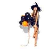 Halloween party girl. witch holding black and orange air balloons