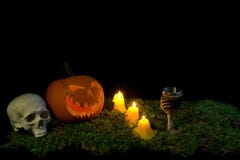 Halloween pumpkin, human skull, goblet and candles glowing in th royalty free stock image Halloween pumpkin, human skull, goblet and candles glowing in th royalty free stock image