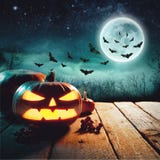 Halloween Pumpkins On Wood In A Spooky Forest At Night. Elements of this image furnished by NASA Stock Image Halloween Pumpkins On Wood In A Spooky Forest At Night. Elements of this image furnished by NASA Stock Image