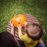 halloween счастливый Отец и небольшие дочери смотрят отрезок стороны во взгляде высокого угла тыквы снаружи стоковые фотографии rf halloween счастливый Отец и небольшие дочери смотрят отрезок стороны во взгляде высокого угла тыквы снаружи стоковые фотографии rf