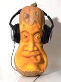 Haloween-Kürbiskopf gemeißelt mit Kopfhörern Lizenzfreies Stockfoto Haloween-Kürbiskopf gemeißelt mit Kopfhörern Lizenzfreies Stockfoto