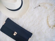 Halsband för hatt och för pärla för kopplingpåse på vit pälsbakgrund Fotografering för Bildbyråer Halsband för hatt och för pärla för kopplingpåse på vit pälsbakgrund Fotografering för Bildbyråer