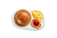 Hamburger, frieten en tomatensaus in een witte ovale plaat die op witte achtergrond wordt ge?soleerd royalty-vrije stock afbeelding Hamburger, frieten en tomatensaus in een witte ovale plaat die op witte achtergrond wordt ge?soleerd royalty-vrije stock afbeelding