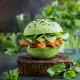 Hamburguer do abacate com os legumes salmon e frescos salgados Imagens de Stock Royalty Free Hamburguer do abacate com os legumes salmon e frescos salgados Imagens de Stock Royalty Free