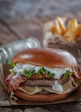 Hamburguer do piano com bacon e costoleta com queijo, tomate, verdes imagem de stock royalty free Hamburguer do piano com bacon e costoleta com queijo, tomate, verdes imagem de stock royalty free