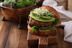 Hamburguesa asada a la parrilla de la haba del vegano con verdes Imagen de archivo libre de regalías Hamburguesa asada a la parrilla de la haba del vegano con verdes Imagen de archivo libre de regalías