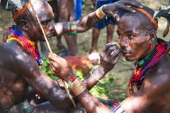 Hamar men paint each other s face in a preparation to a bull jumping. Turmi, Omo Valley, Ethiopia