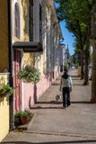 Asian woman and her pug dog walking in the streets of old town of Hamina, Finland in Summer