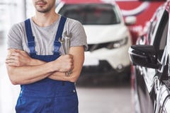 Hand av bilmekanikern med skiftnyckeln Garage för auto reparation royaltyfria bilder Hand av bilmekanikern med skiftnyckeln Garage för auto reparation royaltyfria bilder