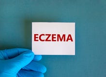 Hand in blue glove with white card. Concept word `eczema`. Medical concept. Copy space