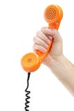 Hand, die ein altes orange Telefongefäß anhält lizenzfreie stockfotos Hand, die ein altes orange Telefongefäß anhält lizenzfreie stockfotos
