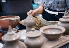 Hand die het traditionele uiteinde van het klei holle beeldhouwwerk op aardewerk gestalte geven wh stock afbeelding Hand die het traditionele uiteinde van het klei holle beeldhouwwerk op aardewerk gestalte geven wh stock afbeelding